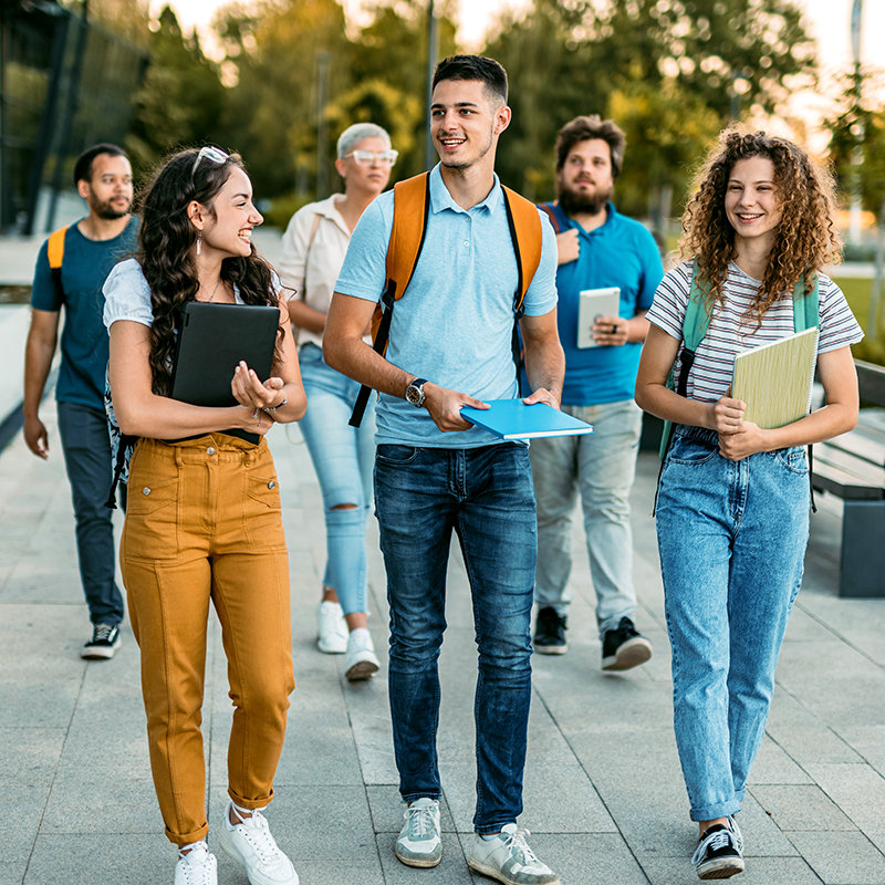 Group Of Smiling Students Walking On College Campus